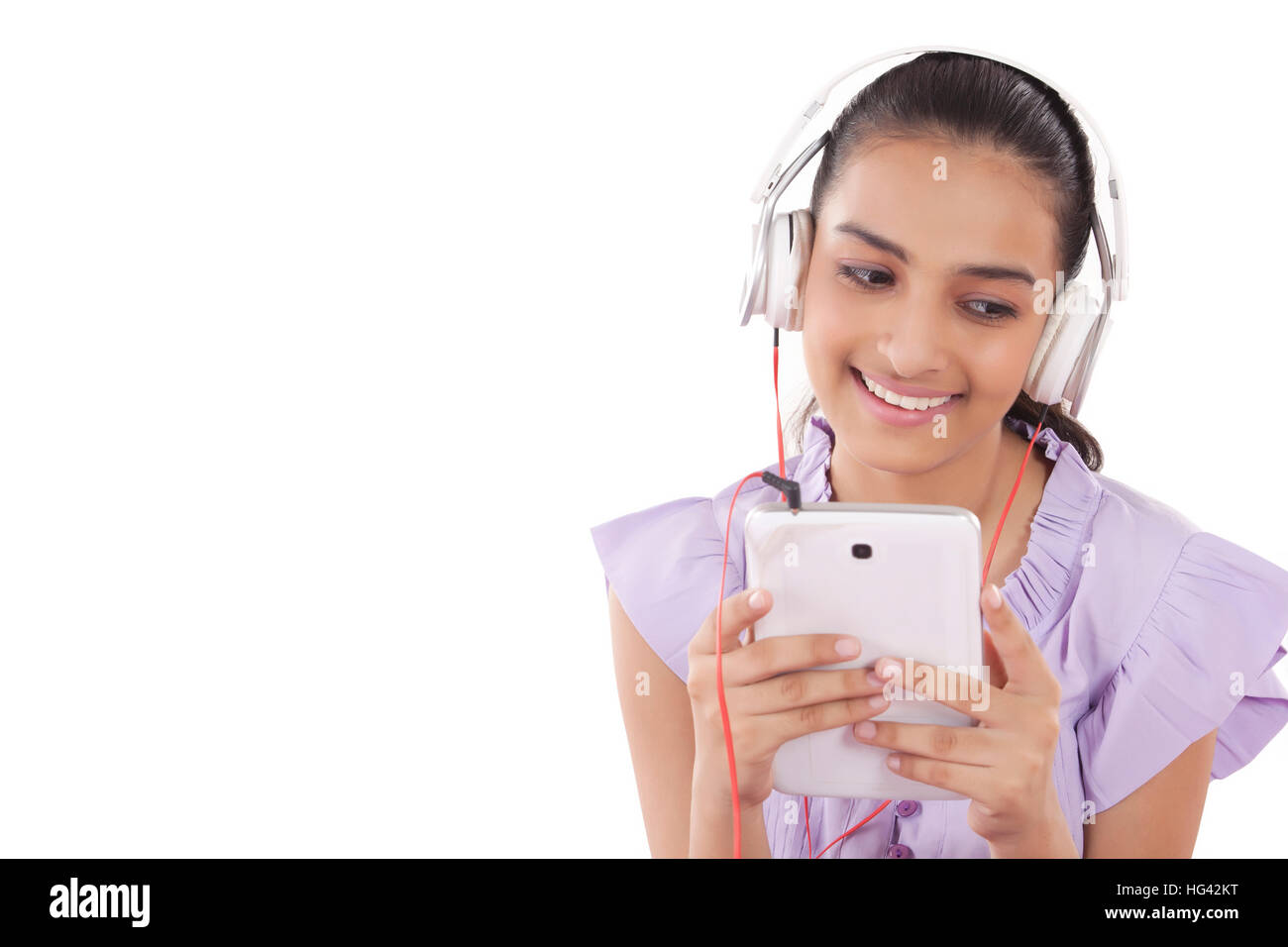 Le ragazze adolescenti godendo della sua musica ascolto di un set di auricolari attaccati al suo tablet Foto Stock