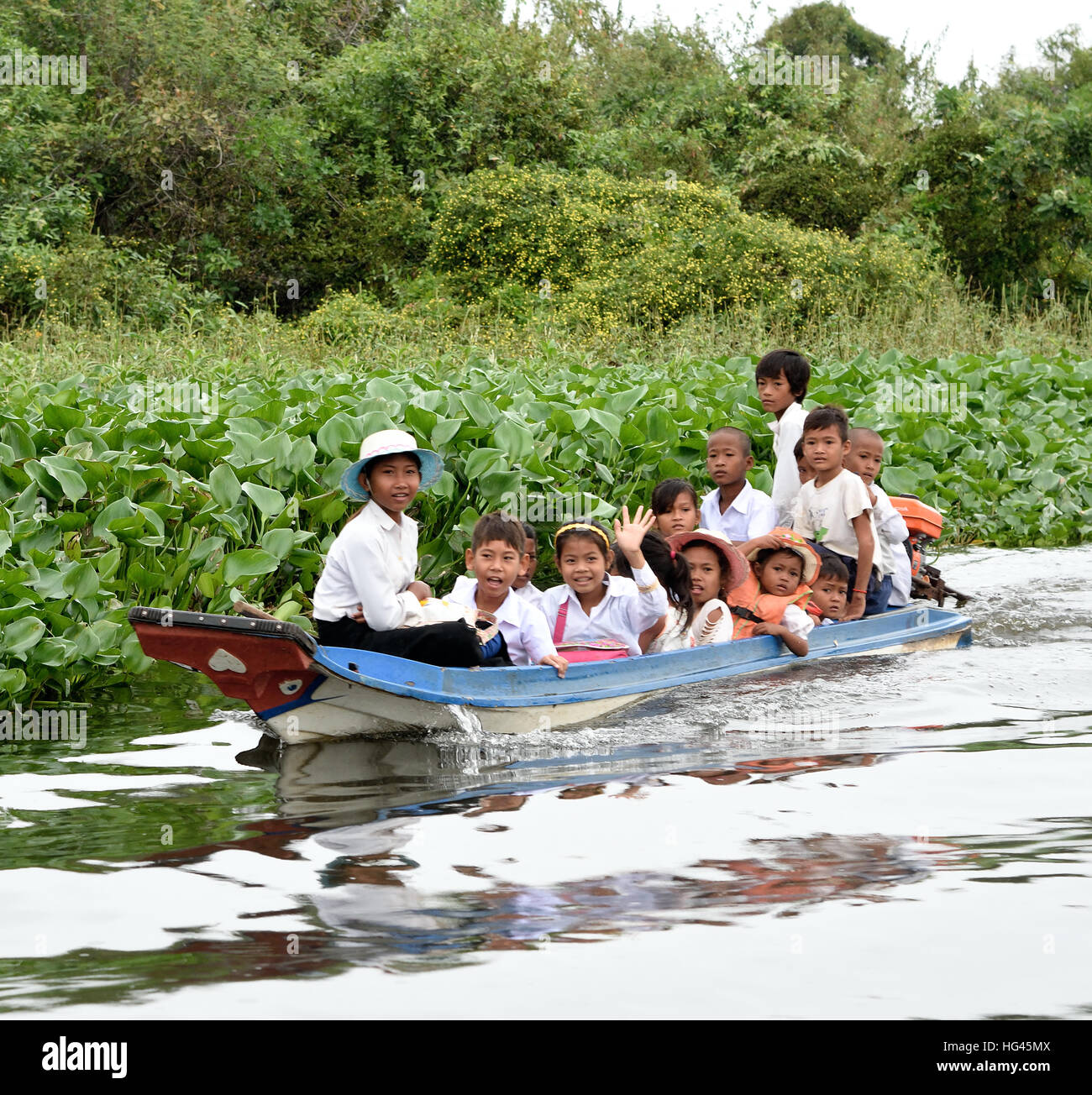 Piccola barca con la scuola dei bambini villaggio galleggiante il Sangkhae - Fiume Sangker Battambang Provincia Cambogia.Il Tonle Sap acqua fresca lago ( più ricca di lago di pesca in tutto il mondo ) drena nel fiume Mekong a Phnom Penh. La locale popolazione cambogiana ha adattato anche per l'ecologia unica del lago con galleggiante ( i pescatori - prodotti della pesca ) villaggi e case artefatta. Foto Stock