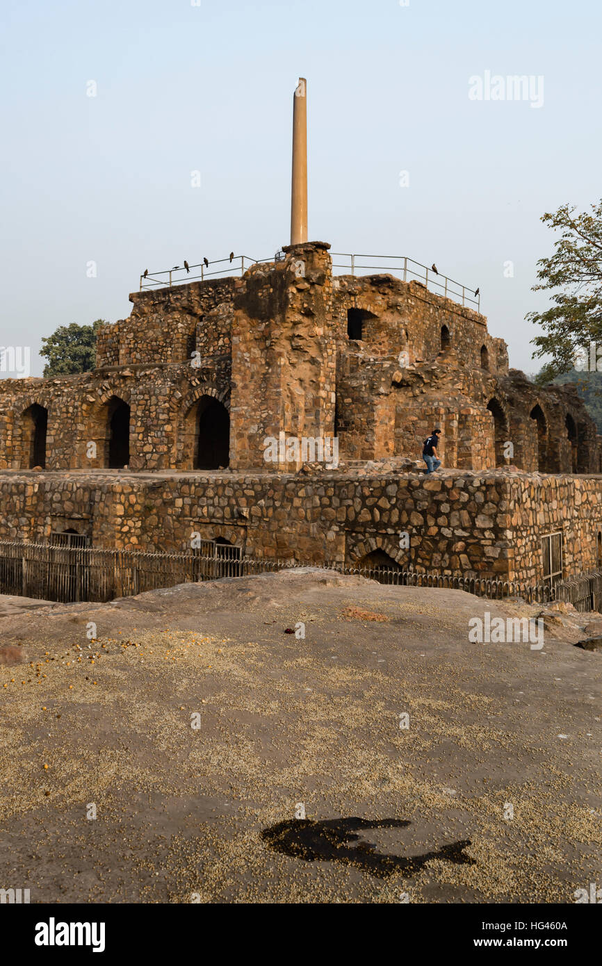 Turista che visita il pilastro di Ashoka sulla struttura piramidale in Feroz Shah Kotla Foto Stock