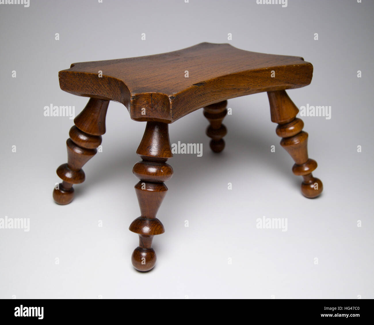 Antiquariato in legno in stile vittoriano table stand di candela o sgabello in miniatura, con parte superiore sagomata e torniti. Il piedistallo misure 10.5cm e alta è di circa Foto Stock