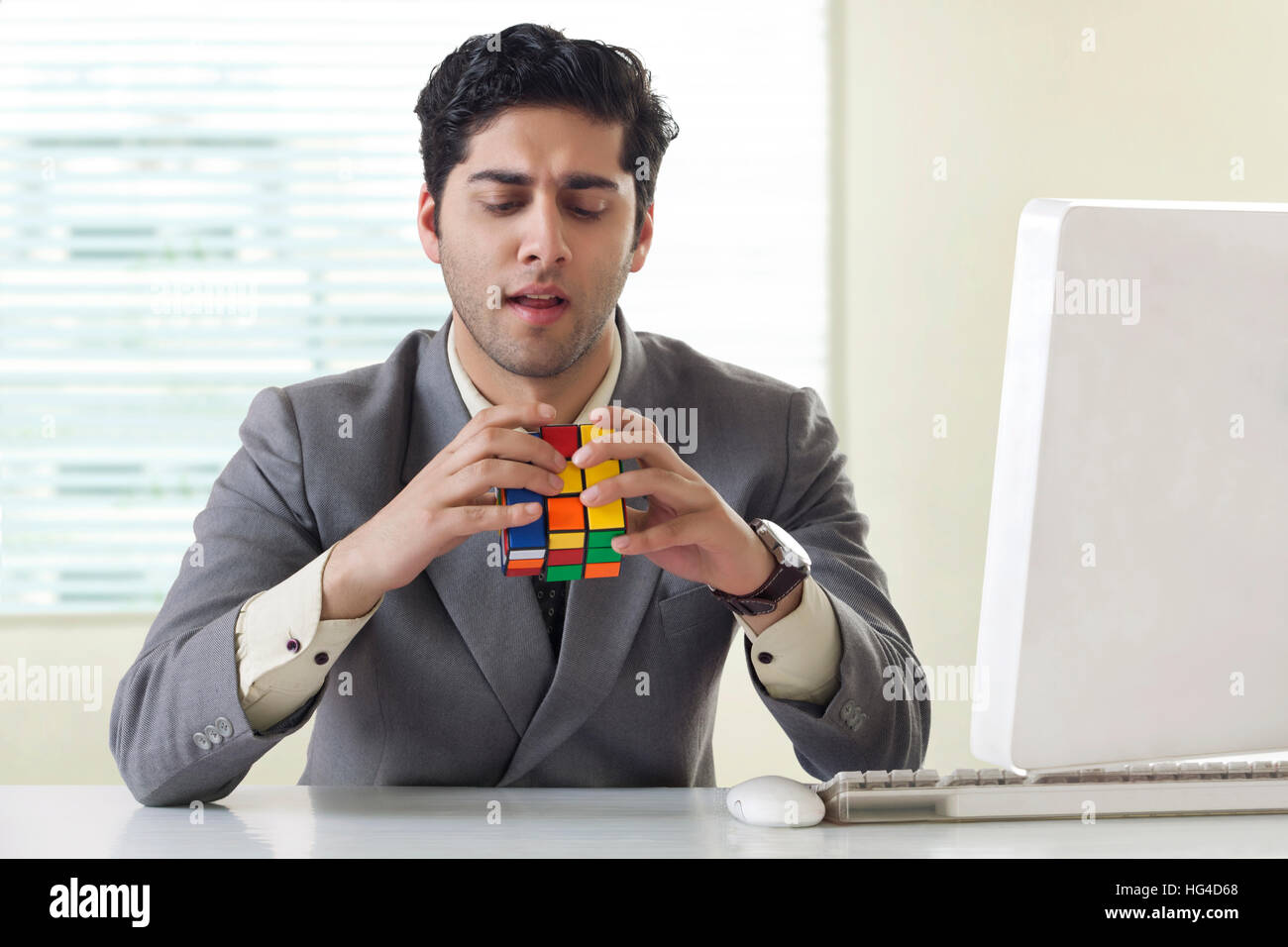 Imprenditore risolvere il cubo di Rubik puzzle Foto Stock