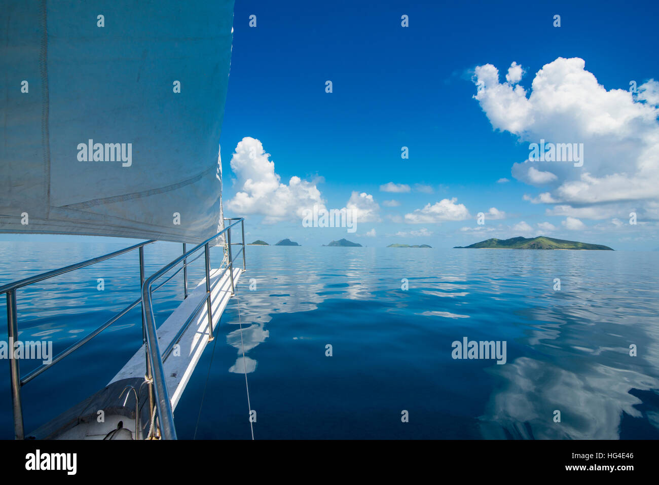 Barca a vela Nei molto piatte acque delle Isole Mamanuca, Figi e Sud Pacifico Foto Stock