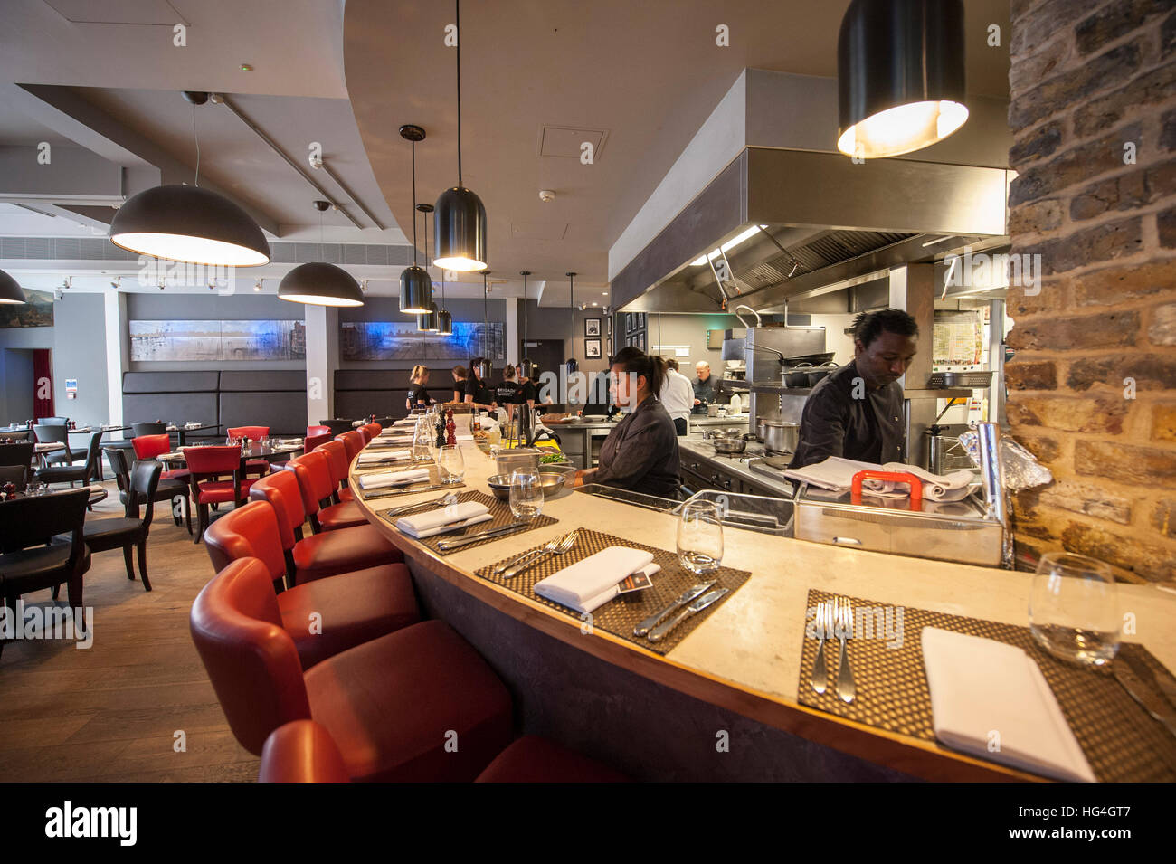 Una barra di forma circolare che si affaccia la cucina aperta a Brigata bar e bistro in Tooley Street Foto Stock