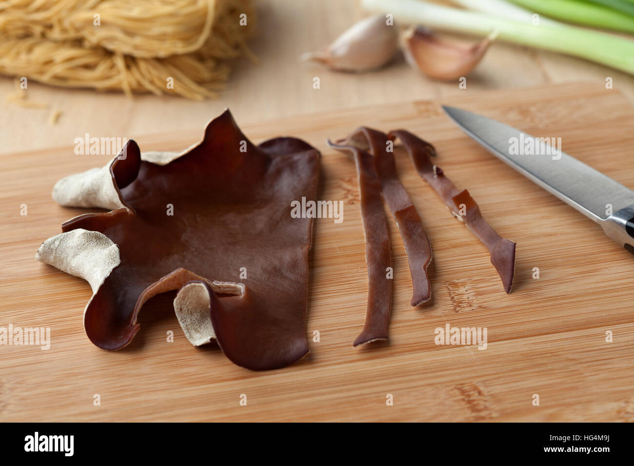 Gli ebrei orecchio funghi tagliati a fettine su un cuttingboard Foto Stock