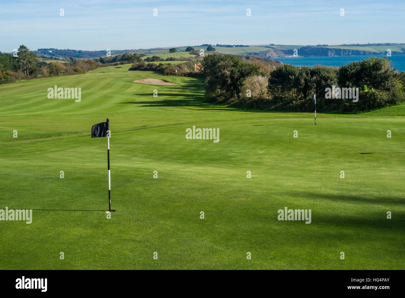 Un bellissimo campo da golf con drammatica sky vicino al mare. Foto Stock