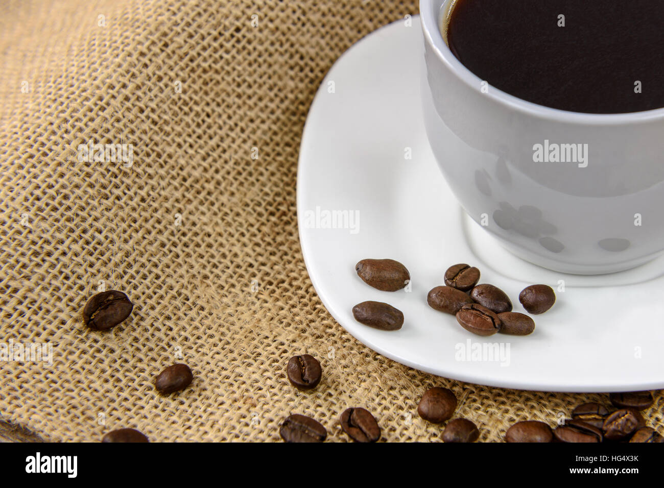 Tazza di caffè con fagioli arrosto su un sacco di tela. Foto Stock