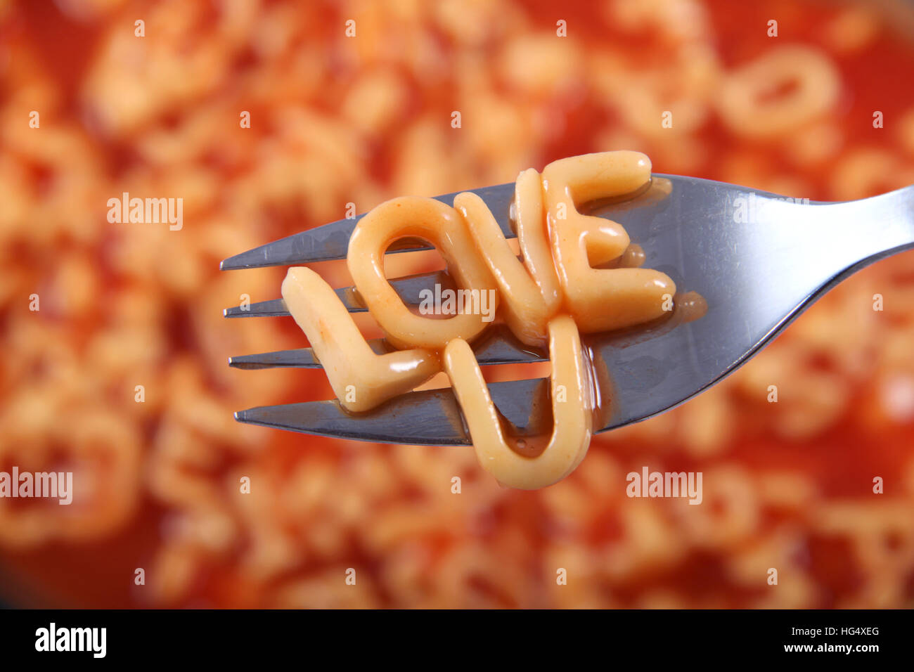 "L'amore U' scritto in spaghetti lettere e poggiante su una forcella per un messaggio speciale per il giorno di San Valentino. Foto Stock