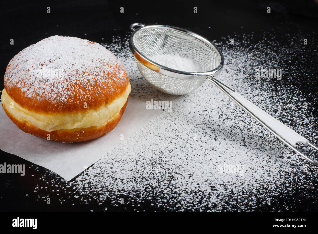 Donut e zucchero a velo su sfondo scuro Foto Stock