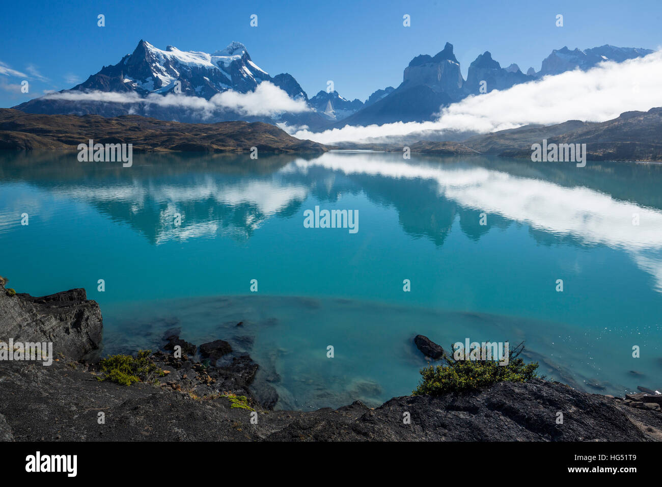 Cancellazione di nebbia sul Lago Pehoe. Poche nuvole basse rimangono, oscurando le basi del Paine Grande e il Cuernos del Paine. Le acque cristalline del lago pr Foto Stock