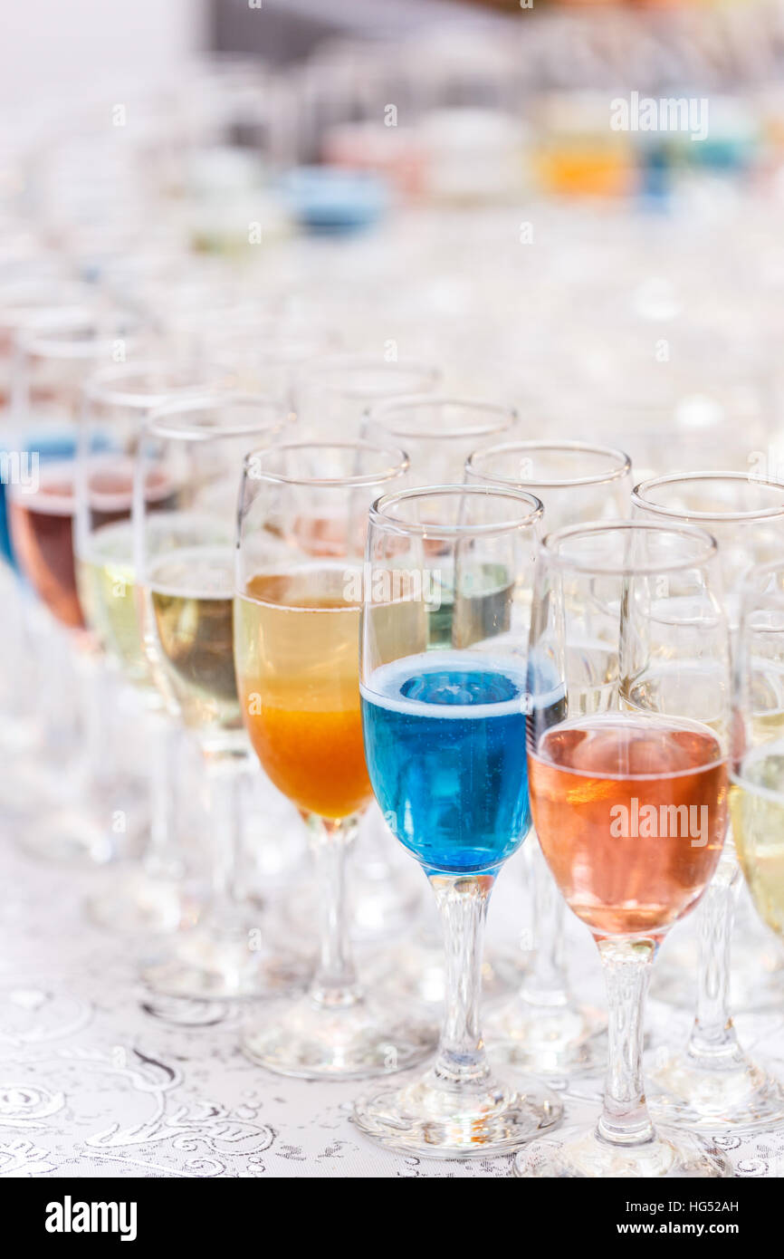 Molti bicchieri di alcool diverso in una fila sul bancone bar Foto Stock