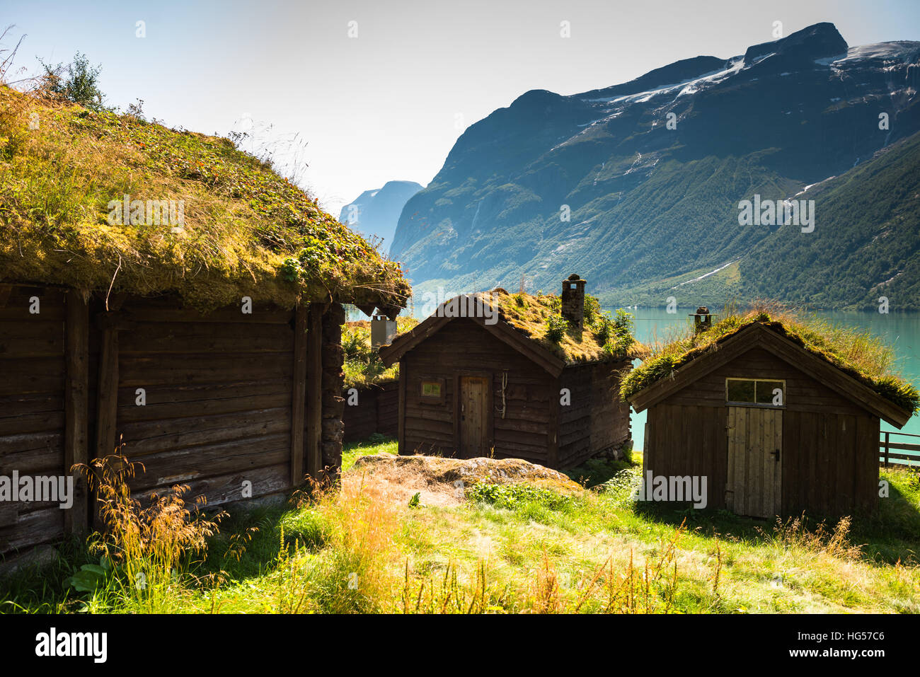 Una vista sul lago Lovatnet, una tradizionale casa norvegese si siede in primo piano e rabboccato con tetto di SOD. Foto Stock