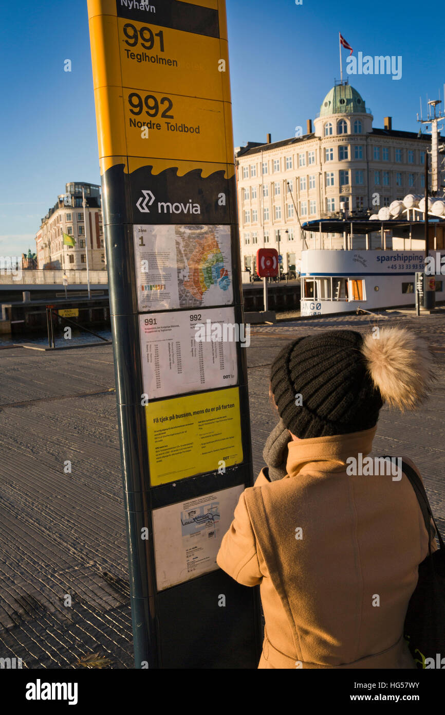 Danimarca Copenhagen Nyhavn, Trasporti pubblici, donna che guarda il calendario sul bus del porto 991 e 992 stop Foto Stock