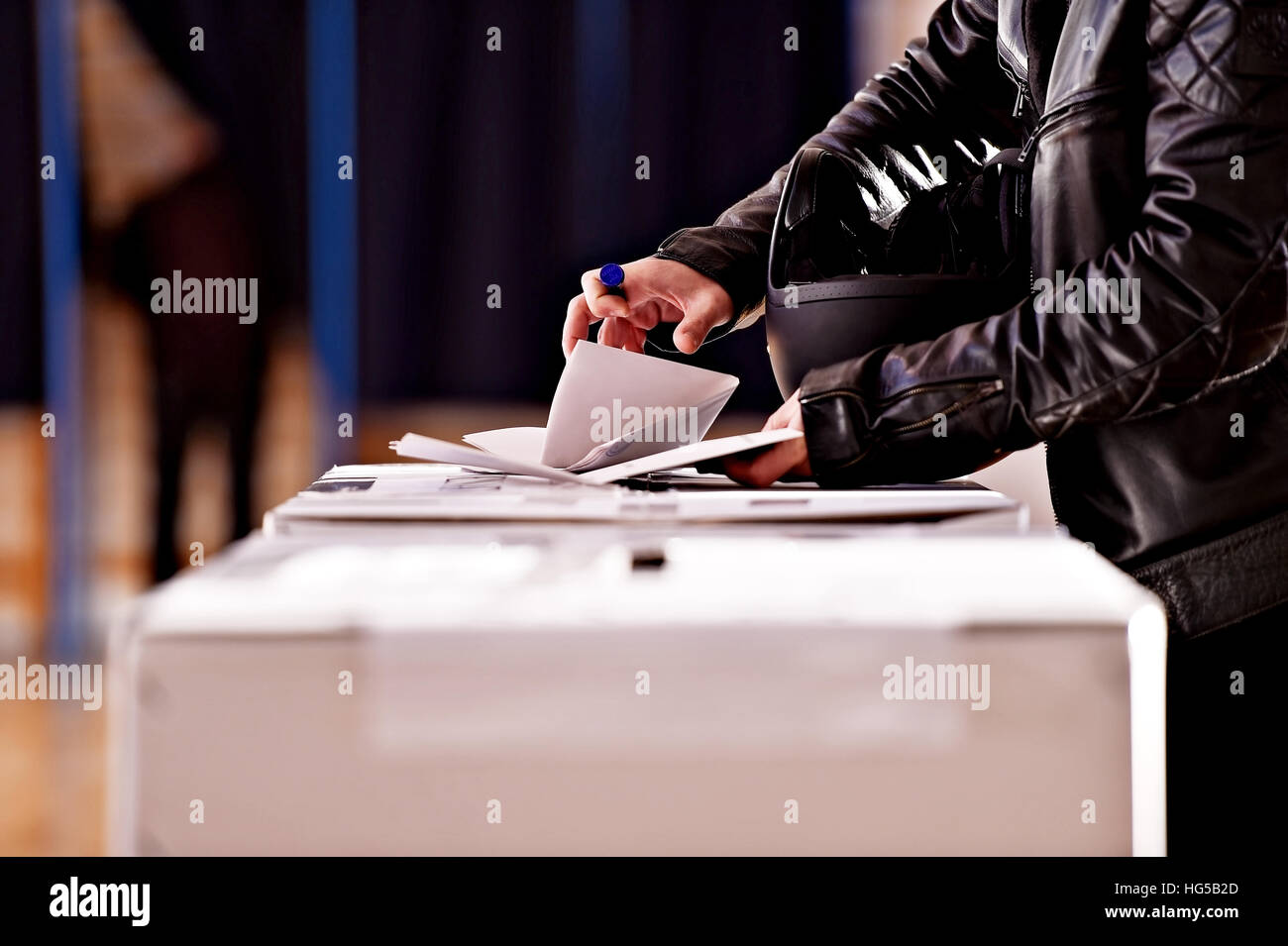 Mani tenendo un timbro colata di un voto nell'urna durante le elezioni Foto Stock