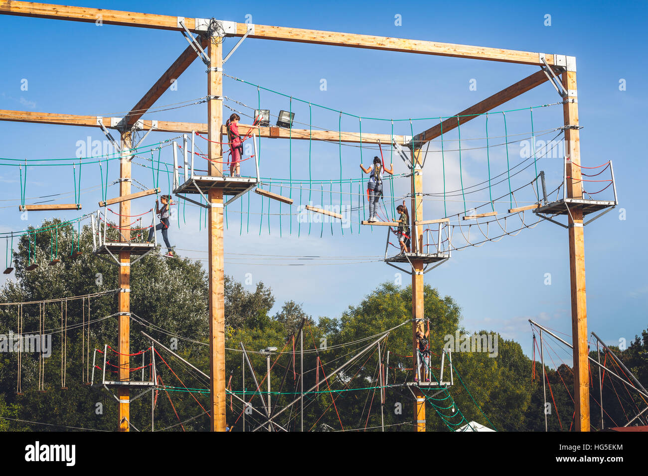 I bambini salendo sulle funi sulle alture del parco tematico di Ferrara, Italia Foto Stock