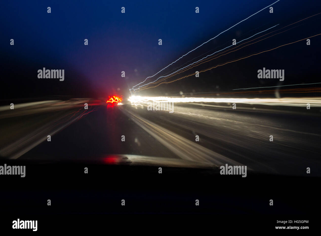 Fari di automobile di lasciare i sentieri della circolazione nel buio della notte. Foto Stock