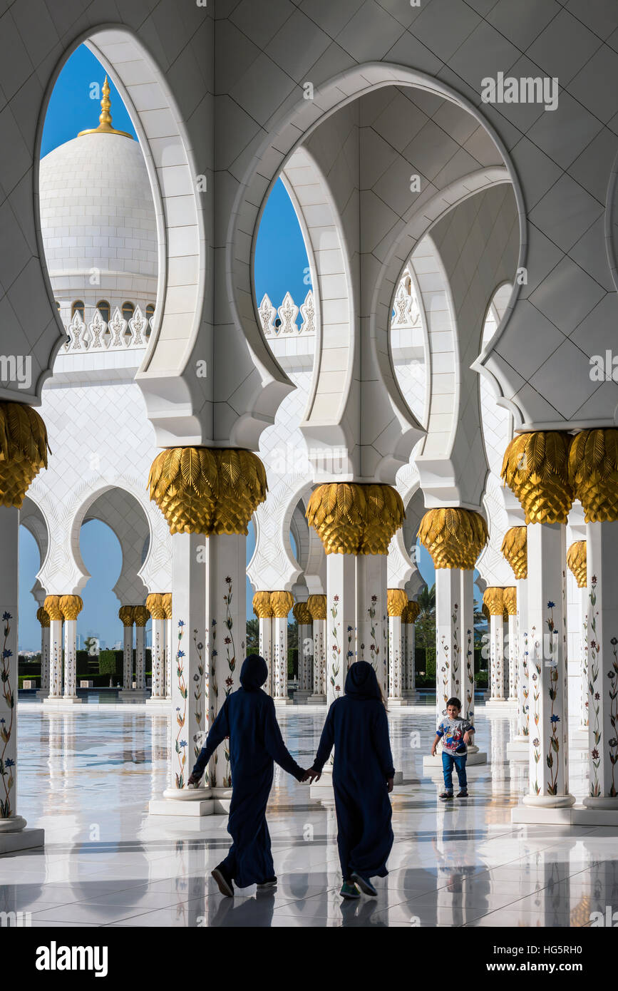 Tradizionalmente condita donne arabe camminando attraverso la Moschea Sheikh Zayed, Abu Dhabi, Emirati Arabi Uniti Foto Stock
