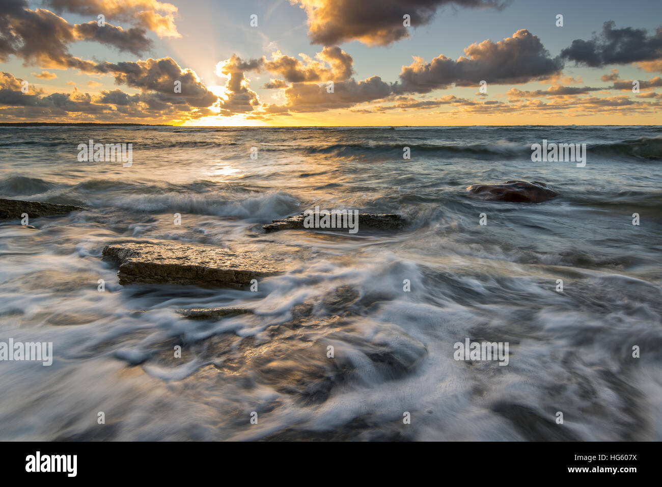 Onde tempestose sulla costa del Mar Baltico al tramonto Foto Stock