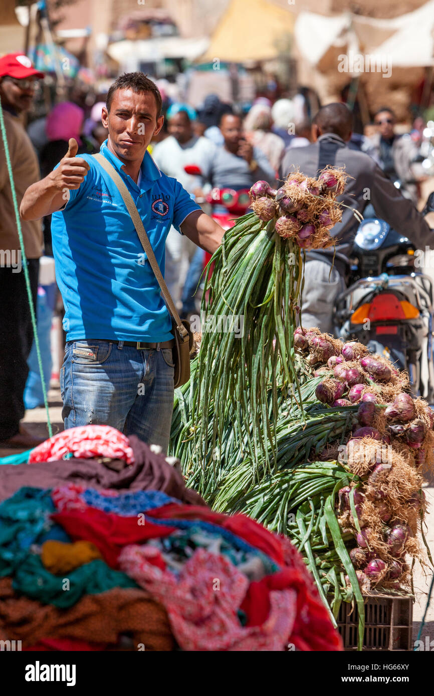 Elkhorbat, Marocco. Giovane berbero uomo cipolle di vendita nel mercato. Foto Stock