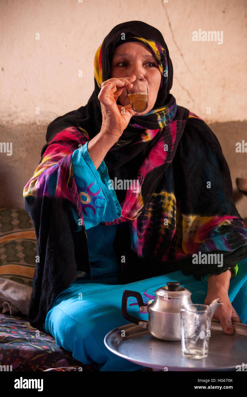 Ksar Elkhorbat, Marocco. Di mezza età Amazigh donna berbera bere il tè nel suo salotto. Foto Stock