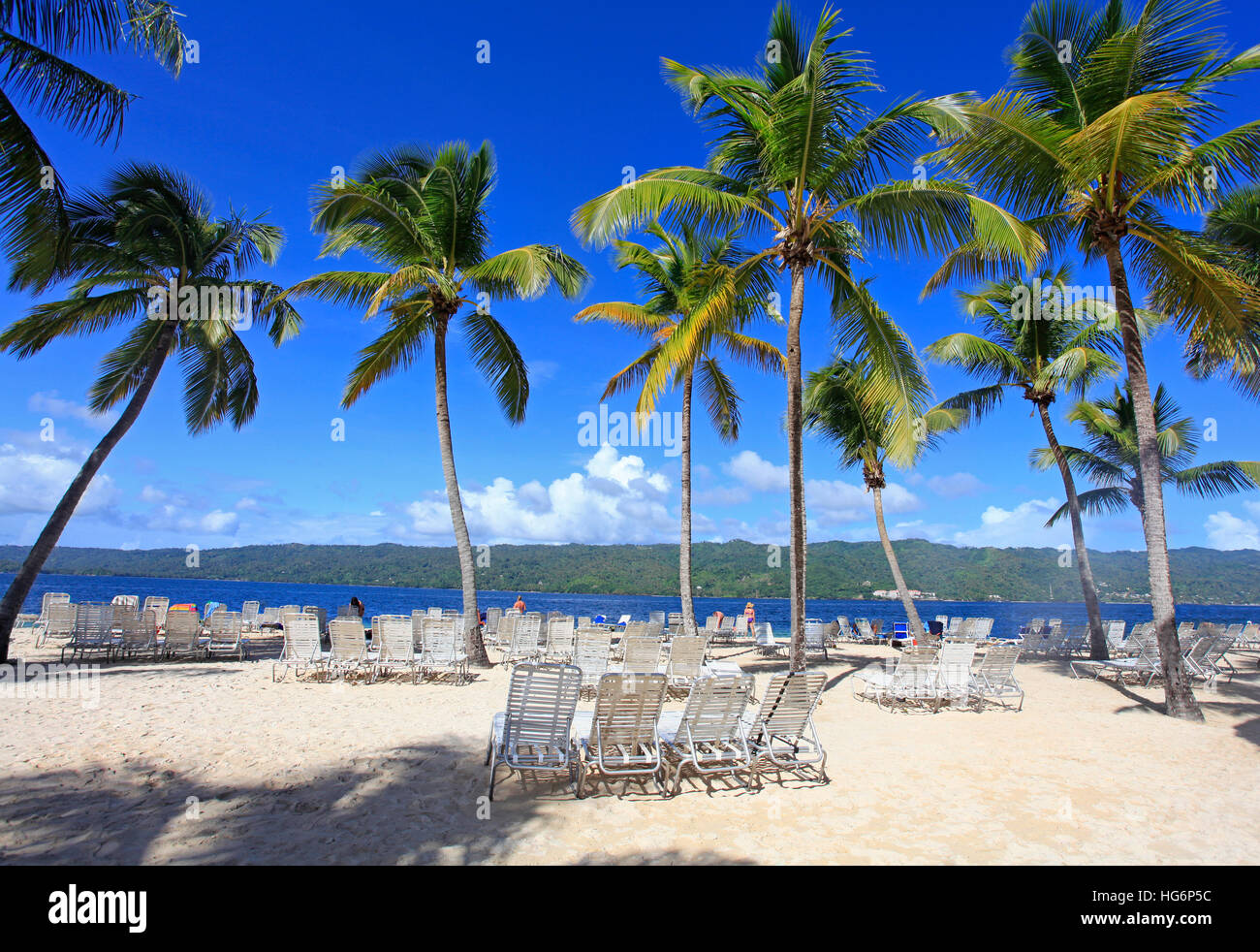 Spiaggia tropicale con blue sedie lunghe e di erba in primo piano Foto Stock