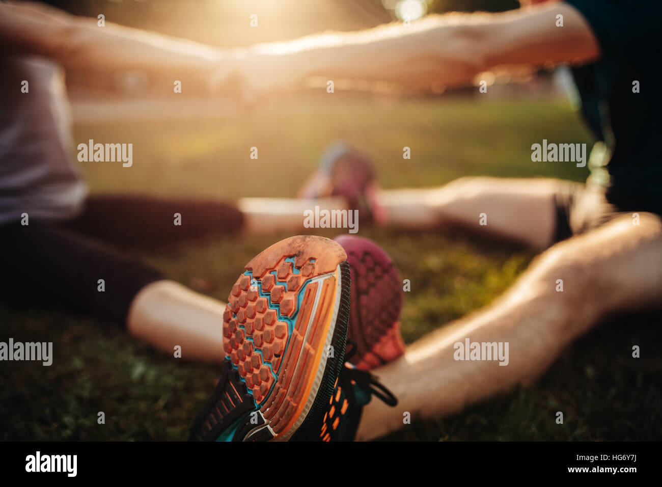 Piedi del giovane uomo e donna che esercitano insieme nel parco. Focus sulle scarpe del giovane lavorando insieme. Foto Stock