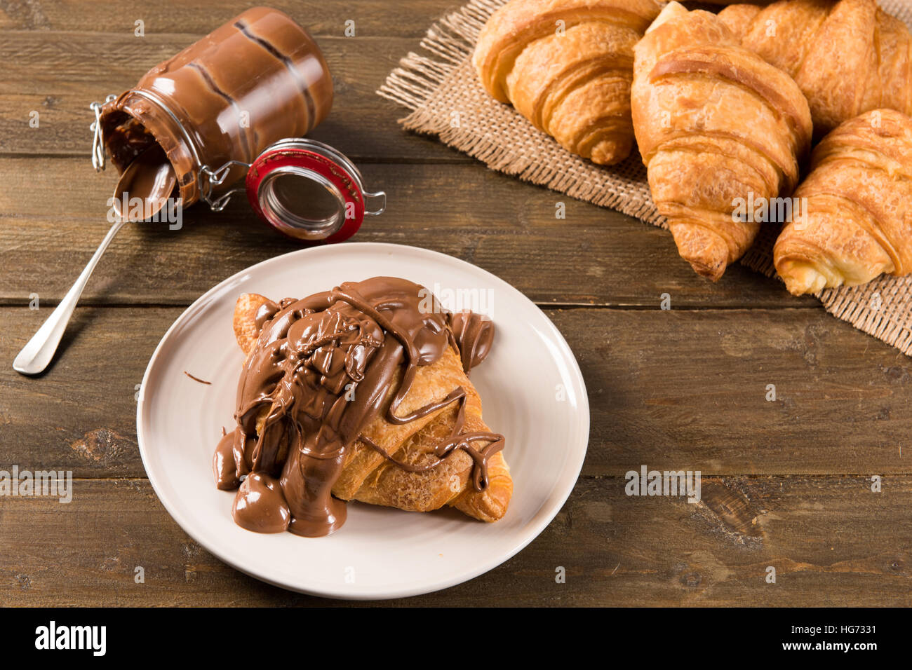 Croissant con crema di cioccolato sul tavolo della luce naturale Foto Stock