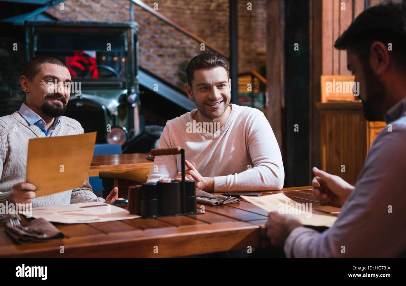 Allegro piacevole gli uomini a discutere il menu Foto Stock