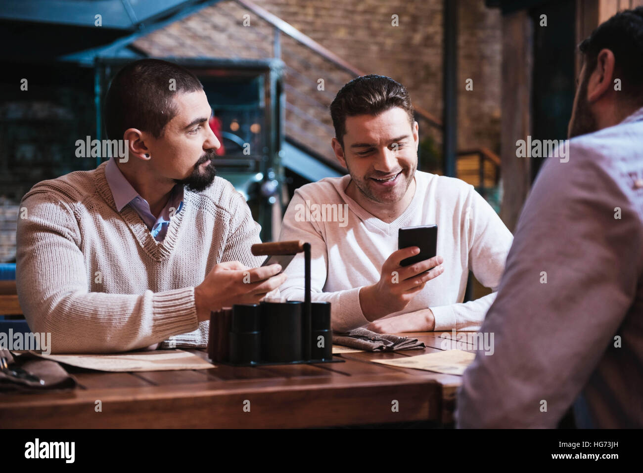 Piacevole uomini positivo tenendo il loro smartphone Foto Stock