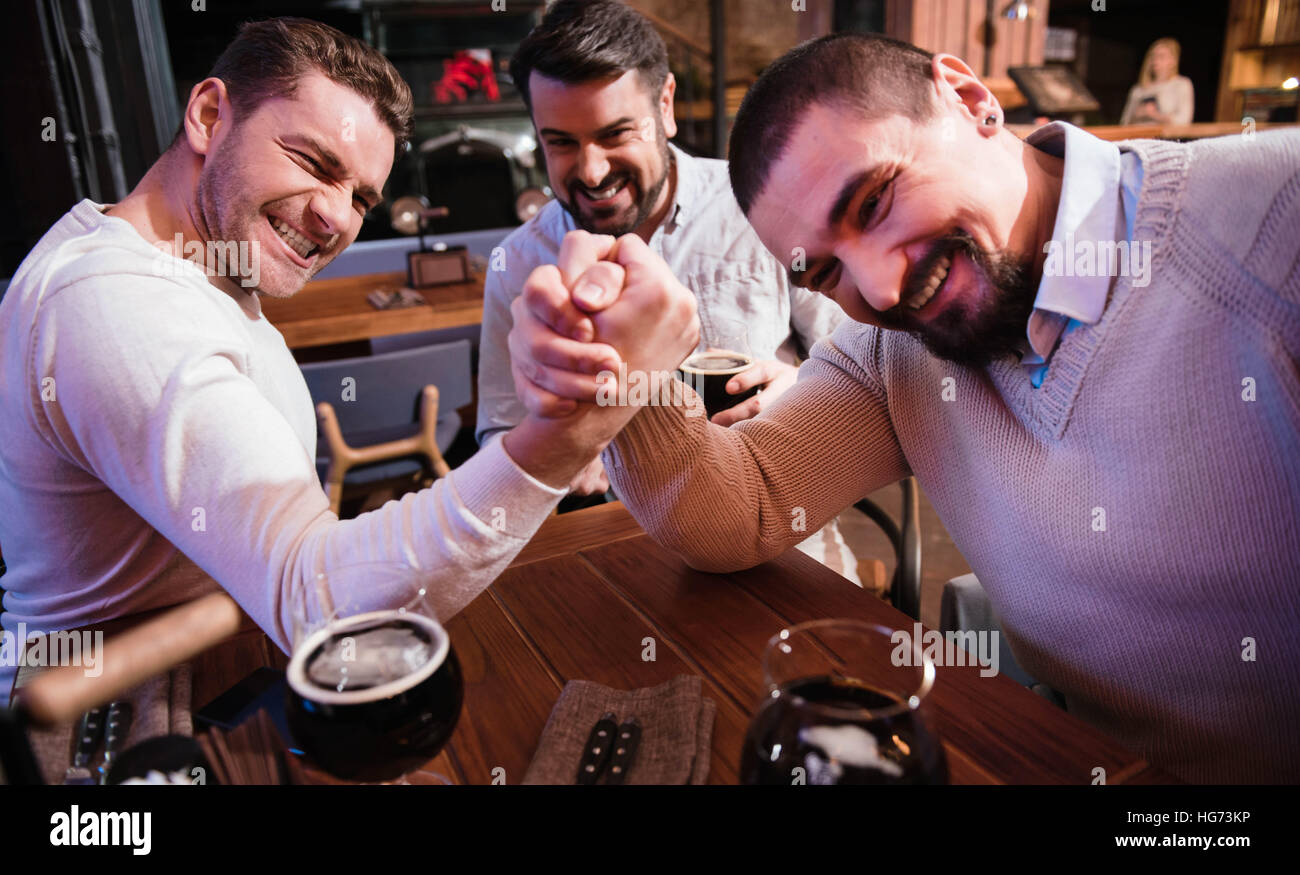 Allegro piacevole uomini armwrestling nel pub Foto Stock