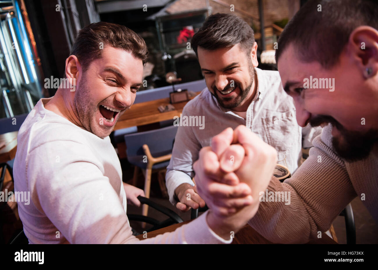 Nizza uomo bello cercando di vincere il match armwrestling Foto Stock