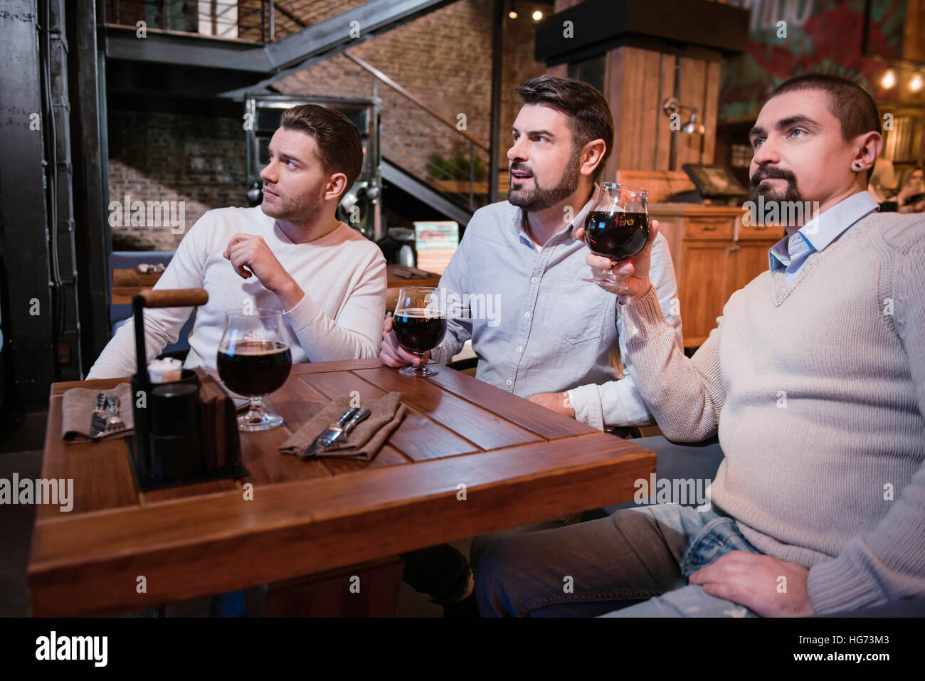 Seri uomini piacevole trascorrere del tempo nel pub Foto Stock