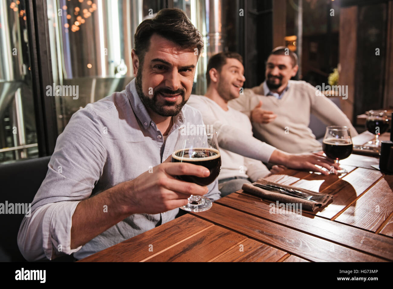 Bel uomo barbuto con in mano un bicchiere di birra Foto Stock