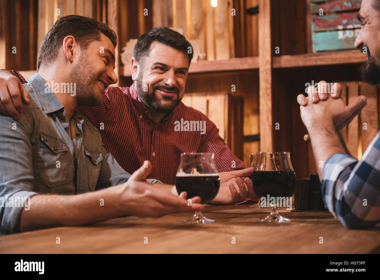 Positivo uomo barbuto abbraccia il suo amico Foto Stock