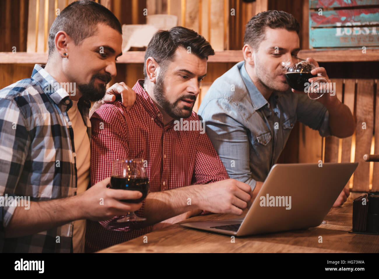 Allegro felici amici guardando lo schermo del laptop Foto Stock