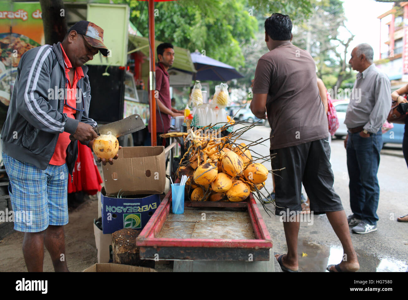 Venditore di cocco preparazione di noci di cocco fresco da bere Foto Stock