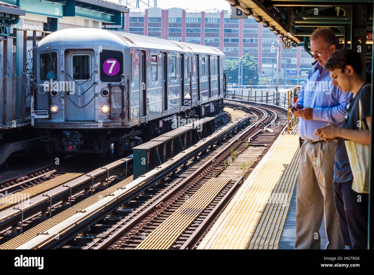 New York City,NY NYC Queens,Long Island City,metropolitana,MTA,Court Square,stazione,piattaforma,treno 7 Line,adulti,uomo uomo maschio,donna donna donna donna donna,chacchi Foto Stock