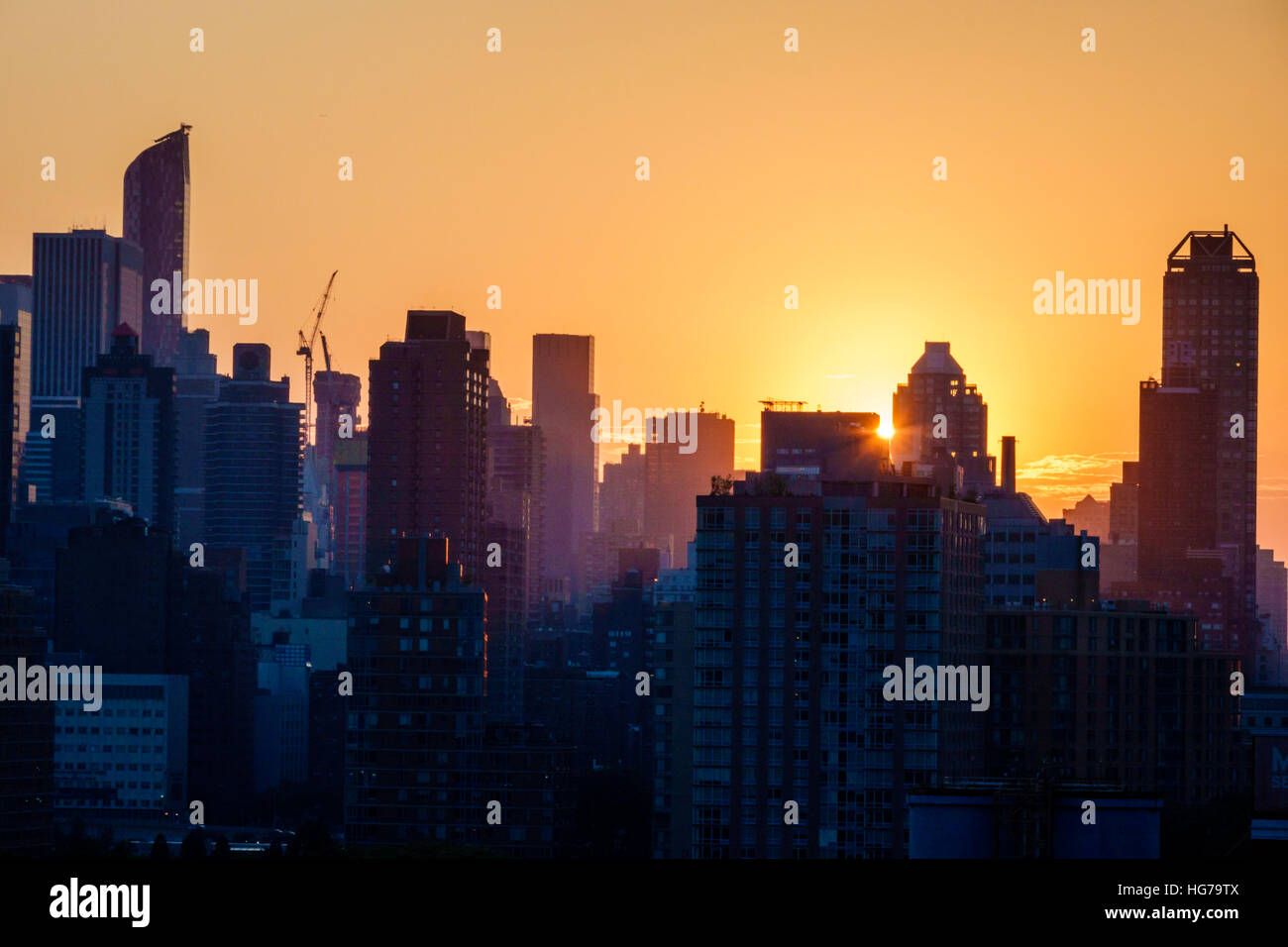 New York City, New York NYC Queens, Long Island City, vista, skyline di Manhattan, edifici, tramonto, raggi solari, arancione, giallo, silhouette, NY160723099 Foto Stock