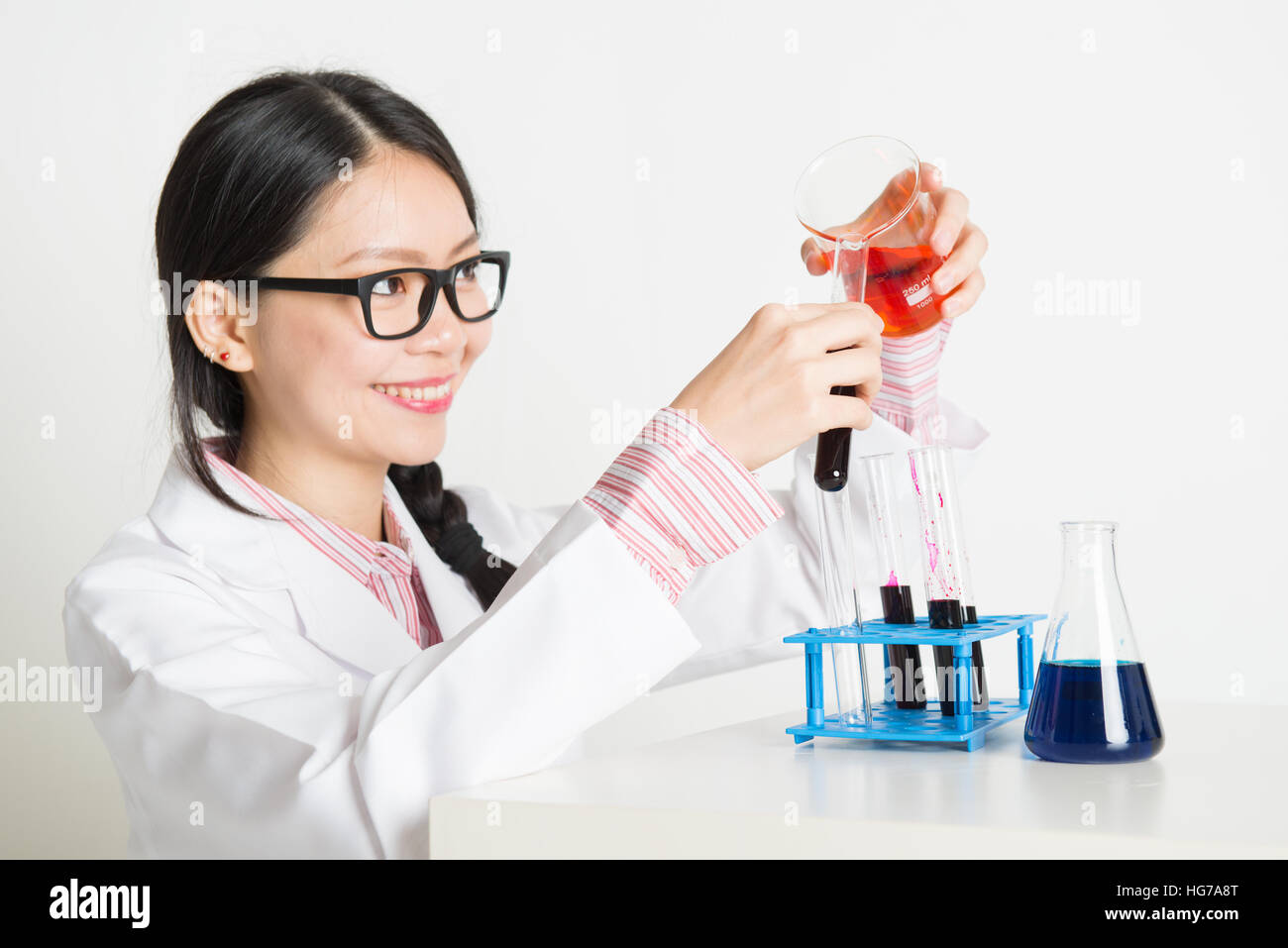 Ritratto di smart e giovani asiatici gli scienziati stanno svolgendo esperimenti in laboratorio con liquido di chimica Foto Stock