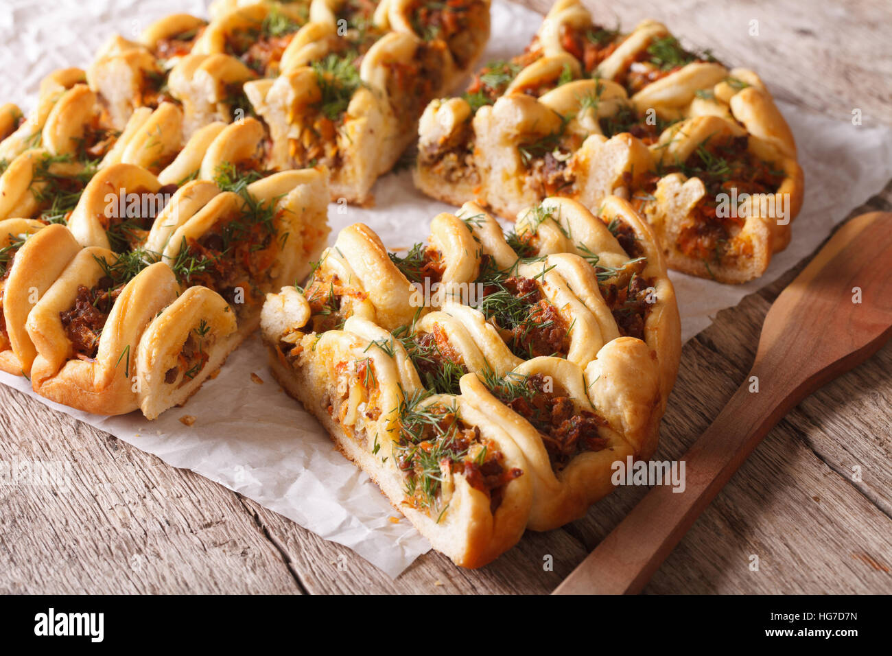 In casa fette di torta con ripieno di carne e verdure vicino sul tavolo orizzontale. Foto Stock