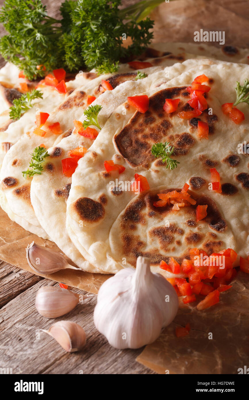 Naan indiano pane piatto con aglio e pepe macro sul piano verticale. Foto Stock