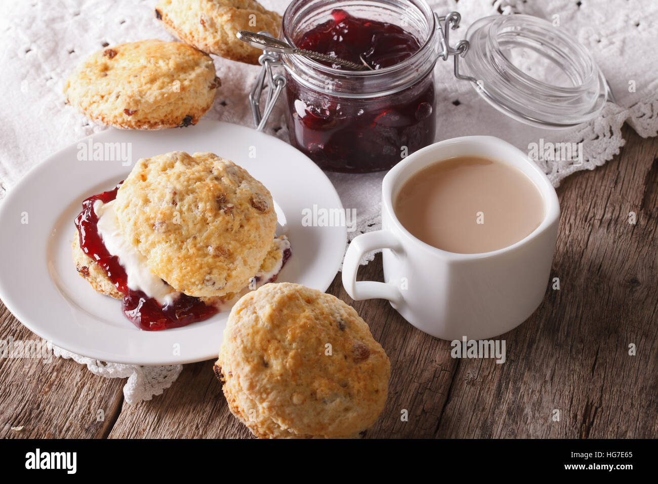 Panini fatti in casa con marmellata e tè con latte vicino sul tavolo orizzontale. Foto Stock