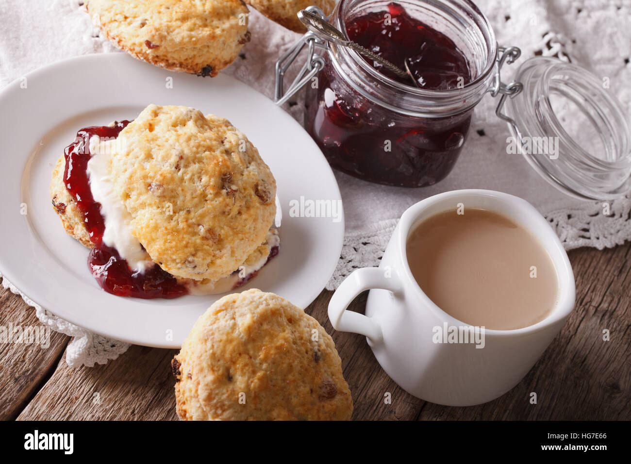Focaccine fatte in casa con marmellata e tè con latte vicino sul tavolo orizzontale. Foto Stock