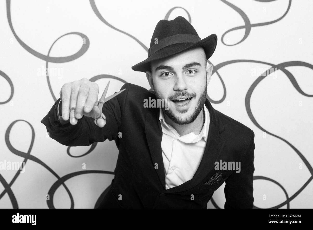 Moda ritratto di un parrucchiere professionista. Uomo che indossa camicia e hat Foto Stock