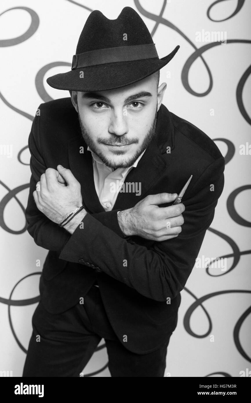 Moda ritratto di un parrucchiere professionista. Uomo che indossa camicia e hat Foto Stock