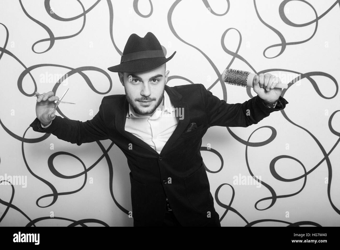 Moda ritratto di un parrucchiere professionista. Uomo che indossa camicia e hat Foto Stock