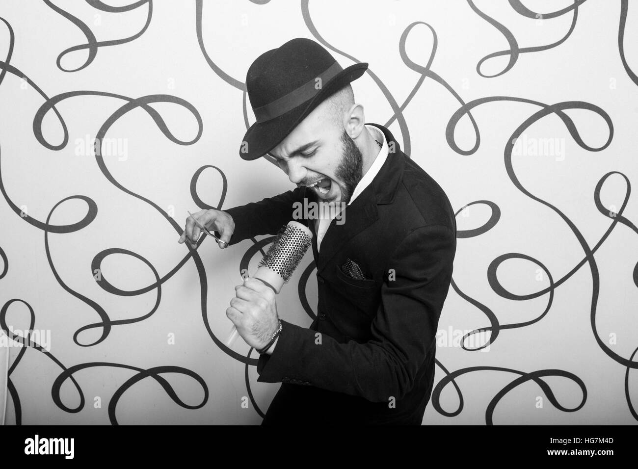 Moda ritratto di un parrucchiere professionista. Uomo che indossa camicia e hat Foto Stock