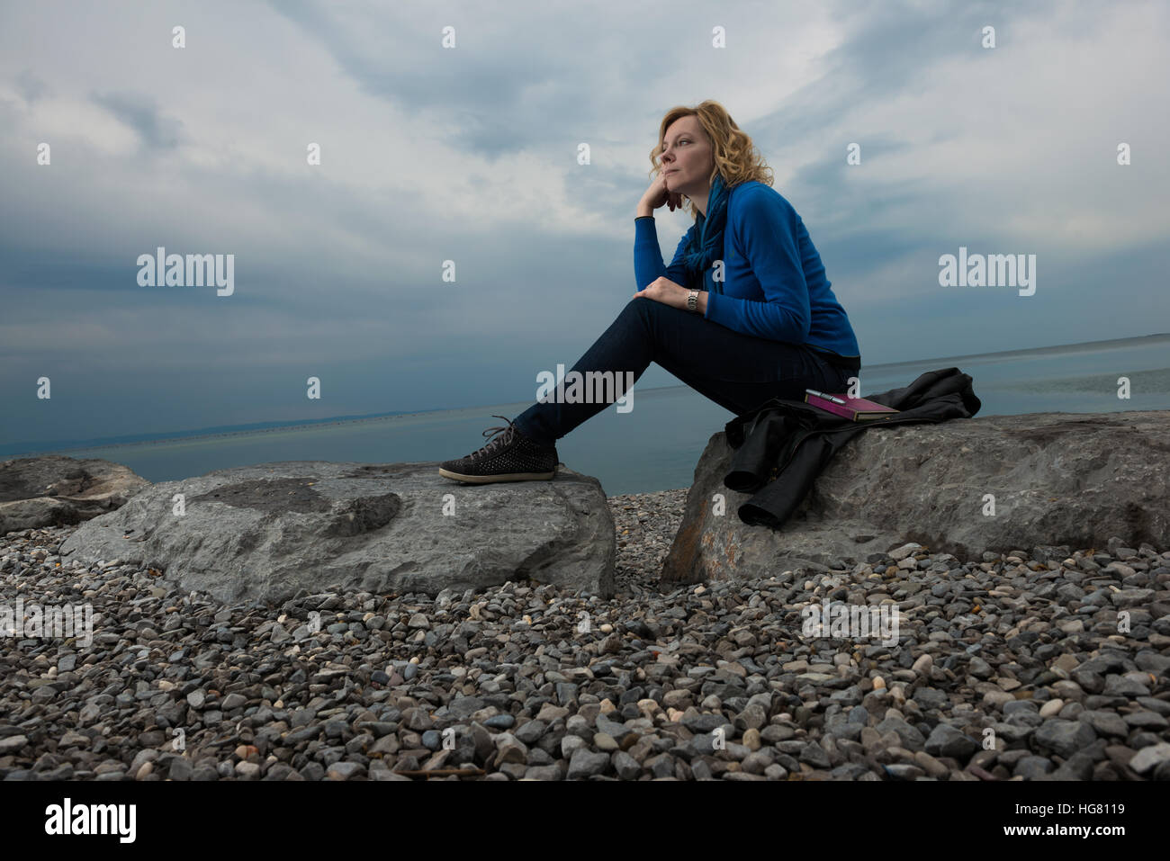 Malinconici donna fantasticando in riva al mare Foto Stock