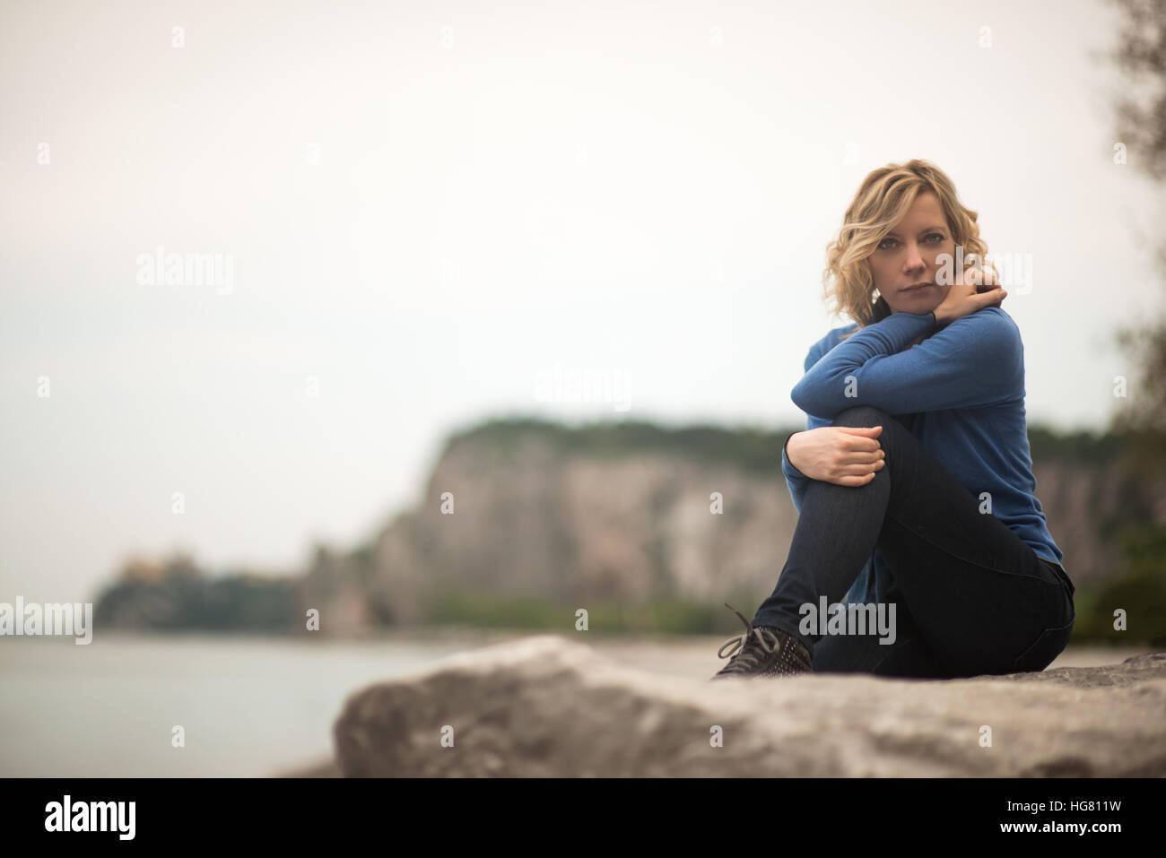 Malinconici donna fantasticando in riva al mare Foto Stock