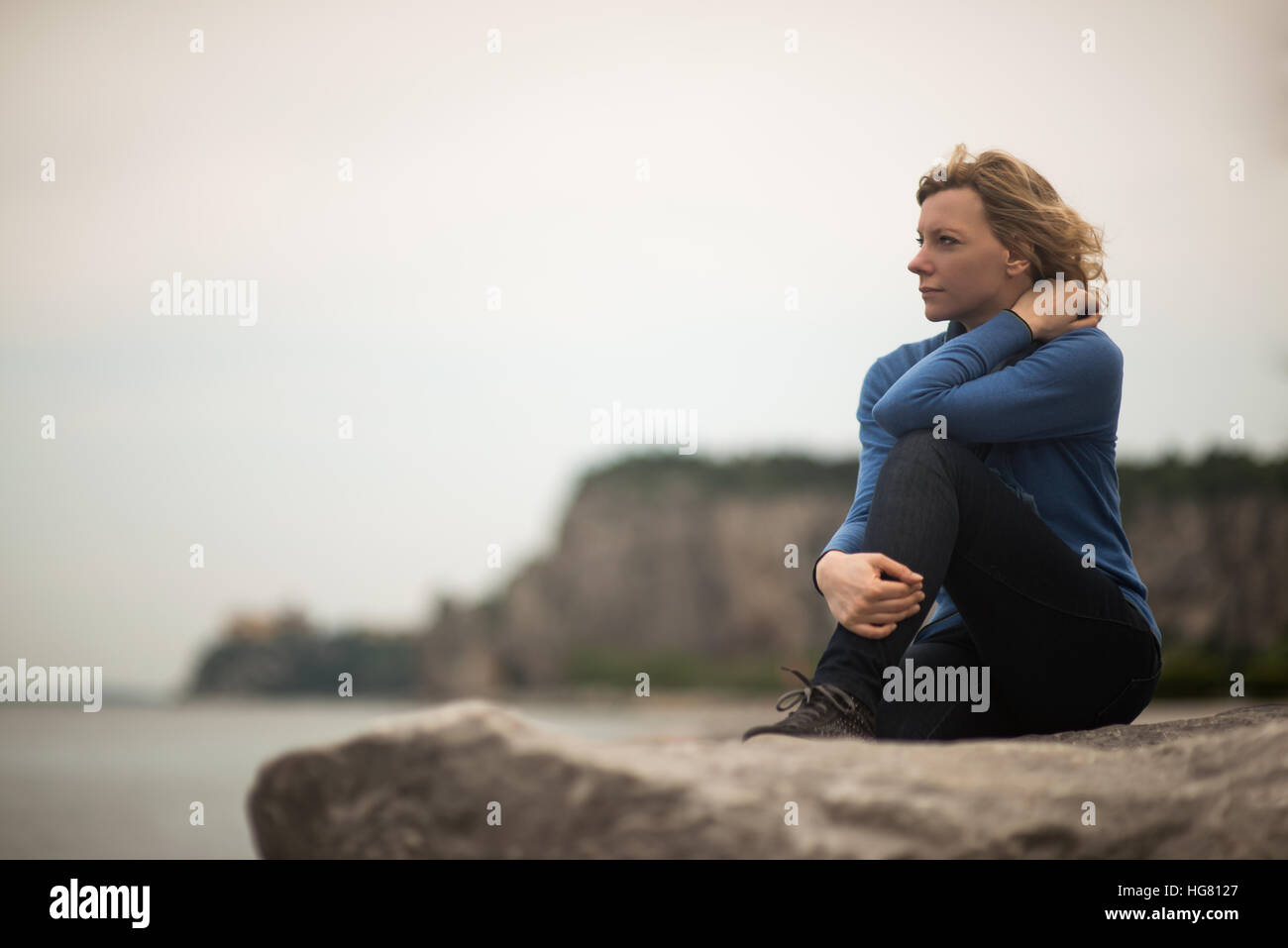 Malinconici donna fantasticando in riva al mare Foto Stock