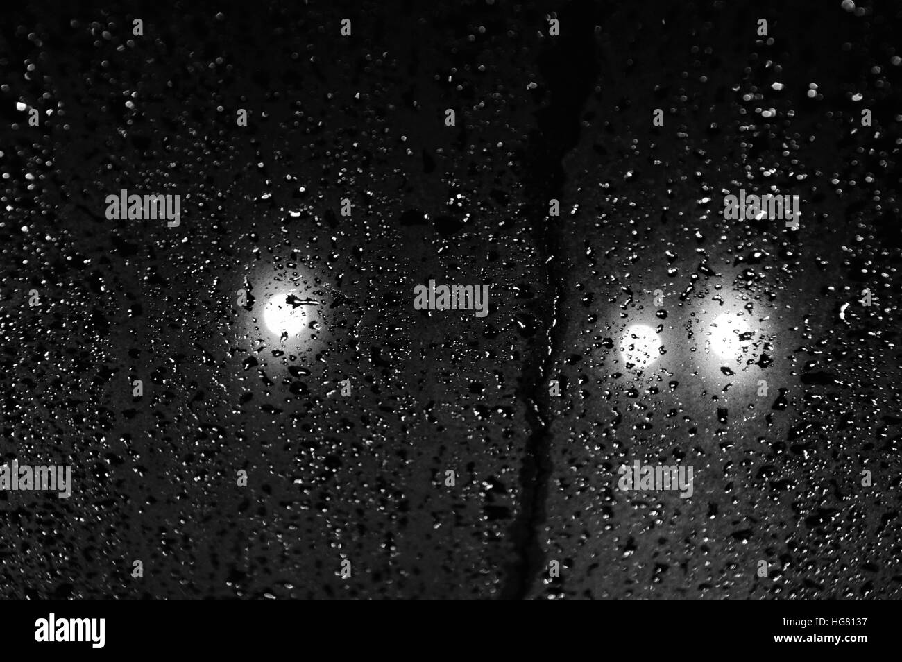 Le gocce di pioggia sulla finestra di notte Foto Stock